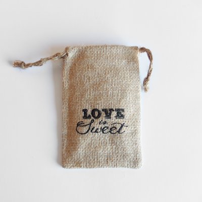Saco de juta castanho claro com cordão e texto 'LOVE Sweet' preto