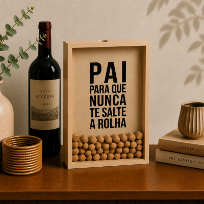 Garrafas, vaso, porta-rolhas, livros e copo decorativo sobre mesa de madeira