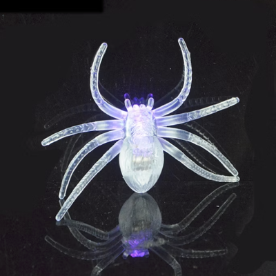 Figura decorativa de aranha translúcida iluminada em superfície negra