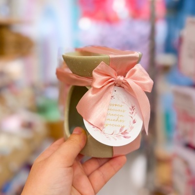 Frasco de cerâmica cinzento com fita rosa e etiqueta redonda