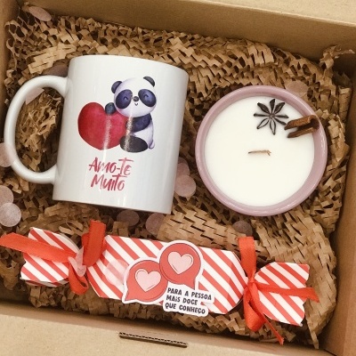 Conjunto com caneca de panda, vela e embalagem decorativa vermelha numa caixa