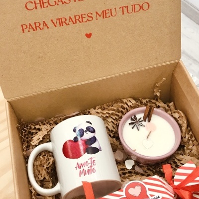 Caixa de presente com caneca de panda, vela aromática e embalagem decorada com texto em português.