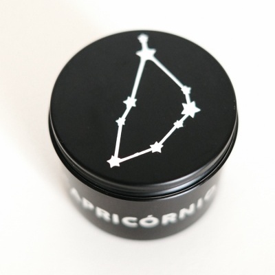 Frasco preto com constelação de Capricórnio branca na tampa e texto CAPRICÓRNIO na lateral