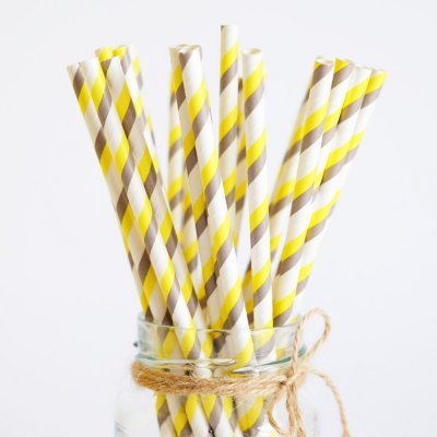Palhinhas de papel às riscas amarelas e cinzentas numa jarra de vidro com corda
