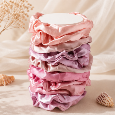 Elásticos de cabelo acetinados em tons rosa e lilás empilhados