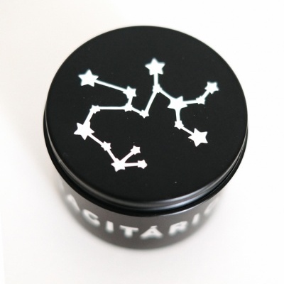 Frasco preto com tampa com desenho de constelação e texto 'SAGITÁRIO'