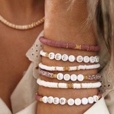 Pulseiras artesanais coloridas com letras em branco no pulso