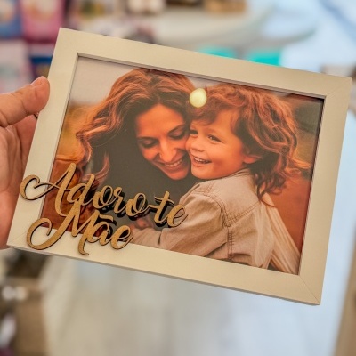 Moldura branca com foto de mulher e criança e texto decorativo em madeira