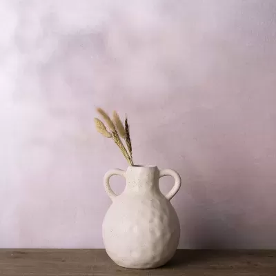 Vaso de cerâmica branco com dois alças contendo ramos secos