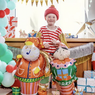 Duas figuras infláveis de Natal com criança ao fundo e decoração festiva