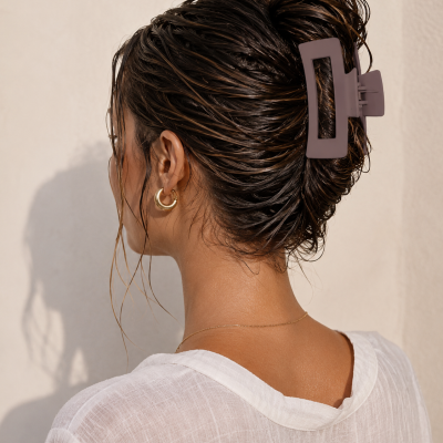 Pregadeira de cabelo castanha fosca usada numa cabeça com cabelo castanho escuro apanhado