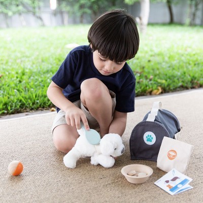 Criança a pentear cão de peluche branco e acessórios para brincadeira