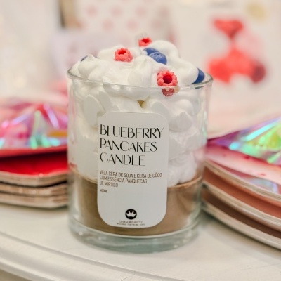 vela aromática blueberry pancakes com detalhes que imitam frutas no topo em copo de vidro transparente