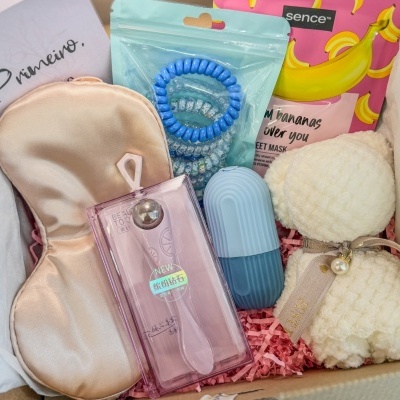 Conjunto de produtos de beleza e autocuidado numa caixa com máscara para olhos, elásticos cabelo, máscara facial e acessórios