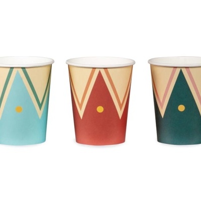 Três copos de papel coloridos com padrões geométricos e um ponto amarelo