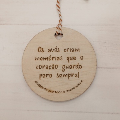 Etiqueta redonda de madeira clara com texto gravado a laser em português e cordão para pendurar