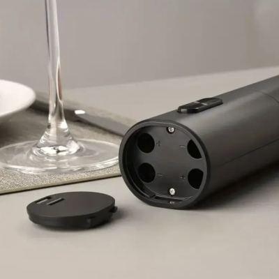 Saca-rolhas elétrico preto numa superfície cinza com base de vidro e sousplat cinza