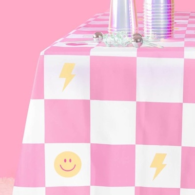 Toalha de mesa rosa e branca xadrez com símbolos e copos prateados