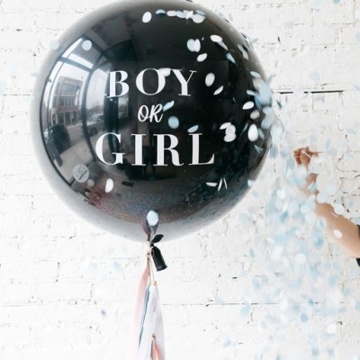 Balão preto com texto 'BOY OR GIRL' e confetis brancos a cair