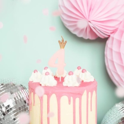 Bolo de aniversário rosa e branco com vela número 4 e decoração em fundo azul