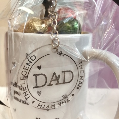 Caneca branca com porta-chaves transparente escrito DAD e bombons embrulhados