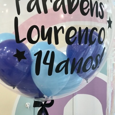 Balão transparente com balões azuis internos e texto preto de parabéns