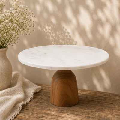Suporte para bolo em madeira e mármore com vaso de flores e tecido bege numa mesa de madeira