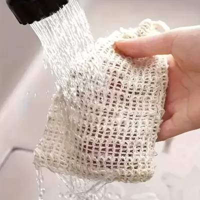 Mão segura saco de tecido branco sob água da torneira