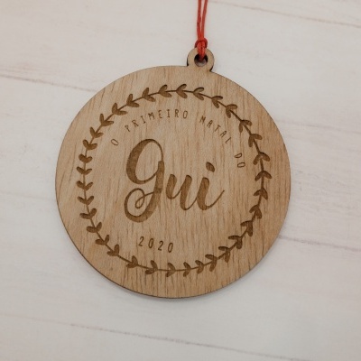 Anel decorativo redondo de madeira com texto gravado e corda vermelha