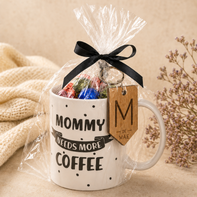 Caneca branca com texto em preto embalada em celofane com laço preto e chaveiro de madeira
