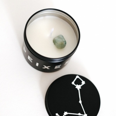 Vela numa lata preta com tampa e pedra verde no centro