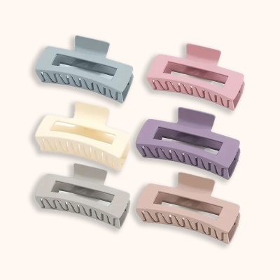 Seis ganchos de cabelo grandes em cores pastel sobre fundo branco