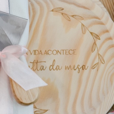 prato de madeira com gravação à volta e guardanapo com fita