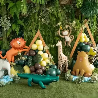 Decoração de festa com balões e figuras insufláveis de animais em ambiente verde