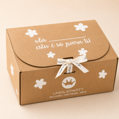 Caixa de cartão castanha decorada com flores brancas e fita com texto, em fundo neutro.
