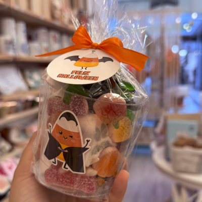 Embalagem com doces coloridos e etiqueta de Halloween com laço laranja