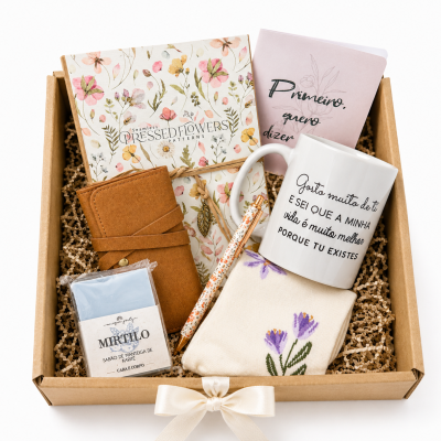 Caixa de oferta com caderno floral, caneta decorada, carteira castanha, sabonete MIRTILO, meias com flores roxas, caneca branca com texto e caderneta rosa