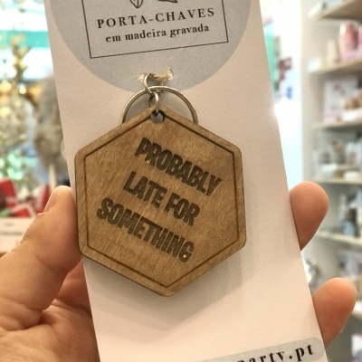 Chaveiro em madeira gravada hexagonal com texto 'PROBABLY LATE FOR SOMETHING'