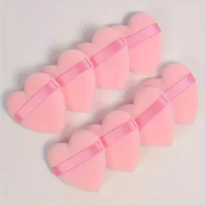 Esponjas em forma de coração cor-de-rosa com faixa rosa em superfície clara