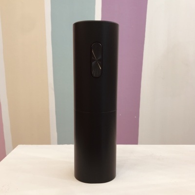 Frasco cilíndrico preto com botão oval no centro