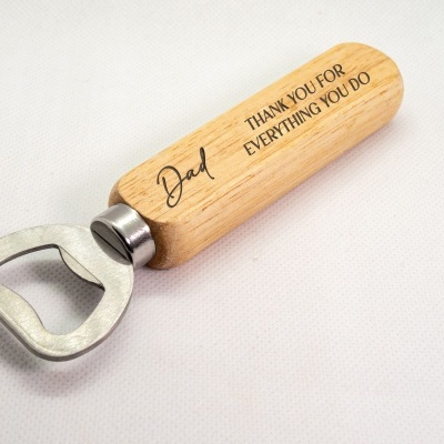 Abridor de garrafas com cabo em madeira clara gravado e parte metálica prateada