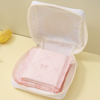 Organizador branco translúcido aberto com tecido rosa dobrado com padrão de laços.