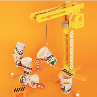 Brinquedo de construção com grua amarela e copos descartáveis decorados em fundo laranja