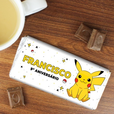Barra de chocolate personalizada com desenho do Pikachu e nome Francisco sobre mesa de madeira