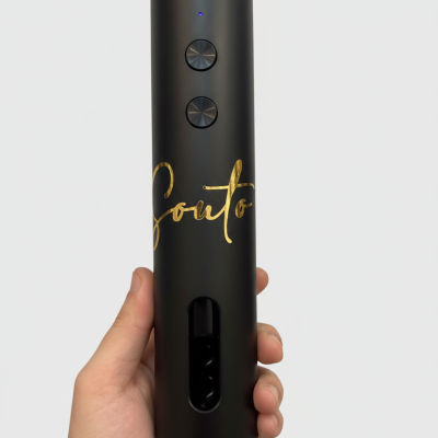 Dispositivo cilíndrico preto com botões metálicos e o nome Souto em dourado