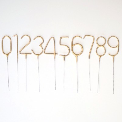 Velas douradas em forma de números 0 a 9 com suportes metálicos finos