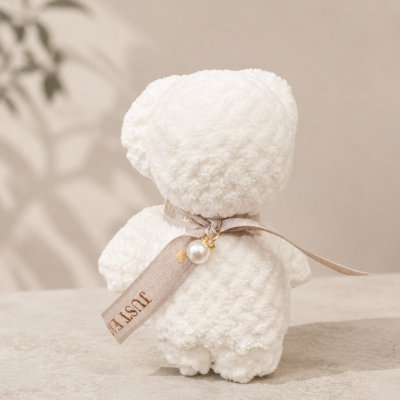 Urso de peluche branco com fita e pérola no pescoço