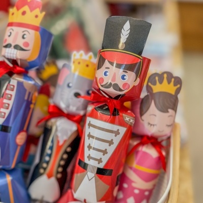 Embalagens decorativas de personagens reais em papel colorido com laços vermelhos