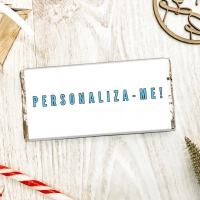Caixa branca personalizada com texto azul sobre mesa de madeira com decoração natalícia.