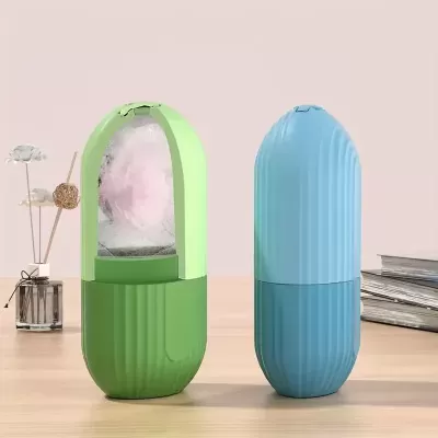Dois humidificadores portáteis em formato cápsula, um verde aberto com vapor e outro azul fechado, sobre mesa com livros e flores secas